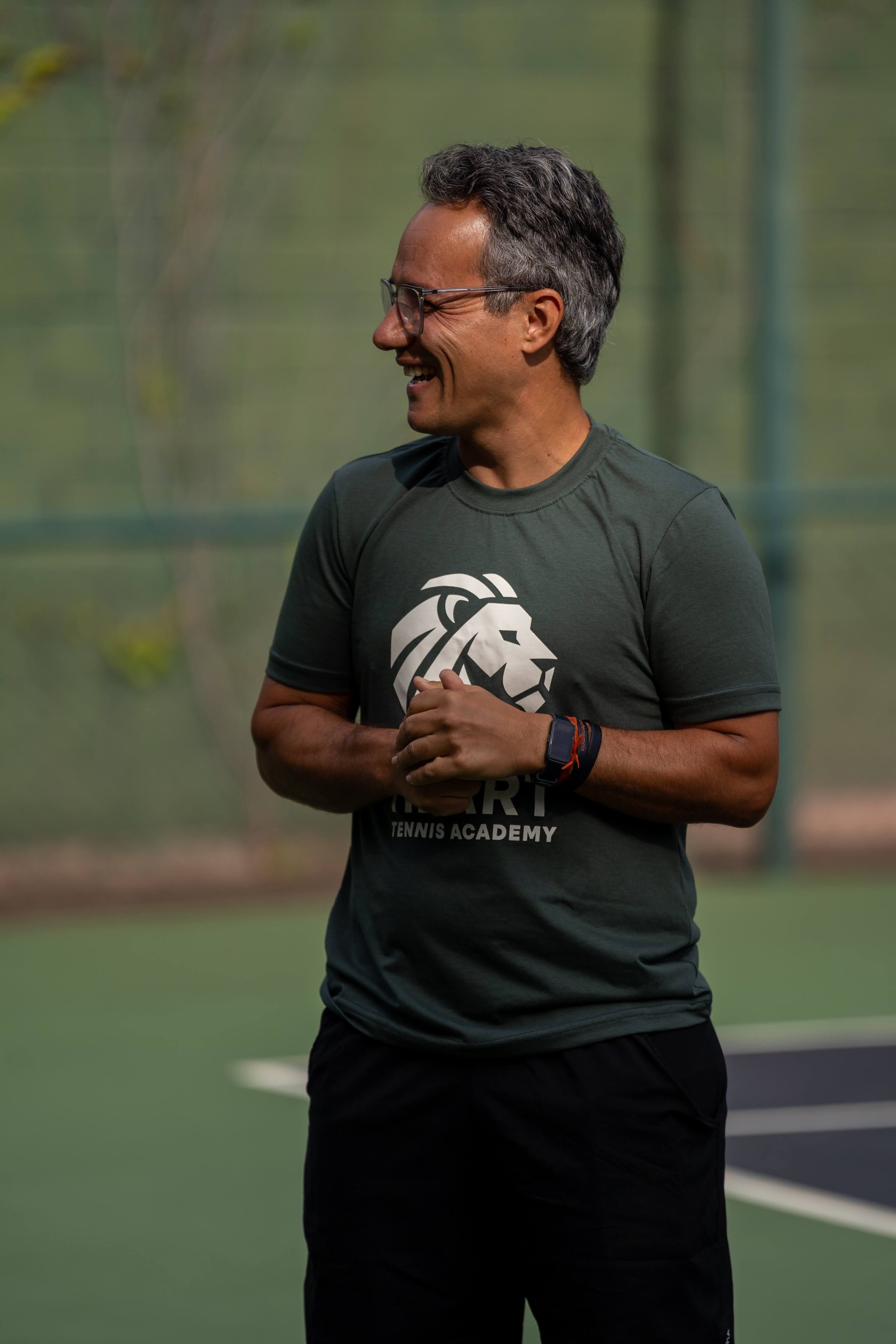 Diogo Stoll sorrindo na quadra da Heart Tennis Academy